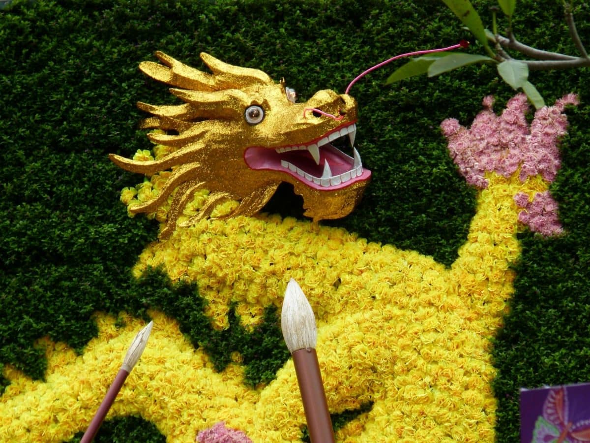 A decorative plant statue of a yellow Chinese dragon, with a golden head